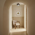 The Margot vessel wall art styled in a serene, neutral hallway with an arched doorway and a checkered accent chair.