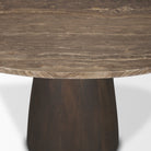 Studio close-up of the Mateo round table showing the polished edge of the marble top and the smooth finish of the wooden pedestal.