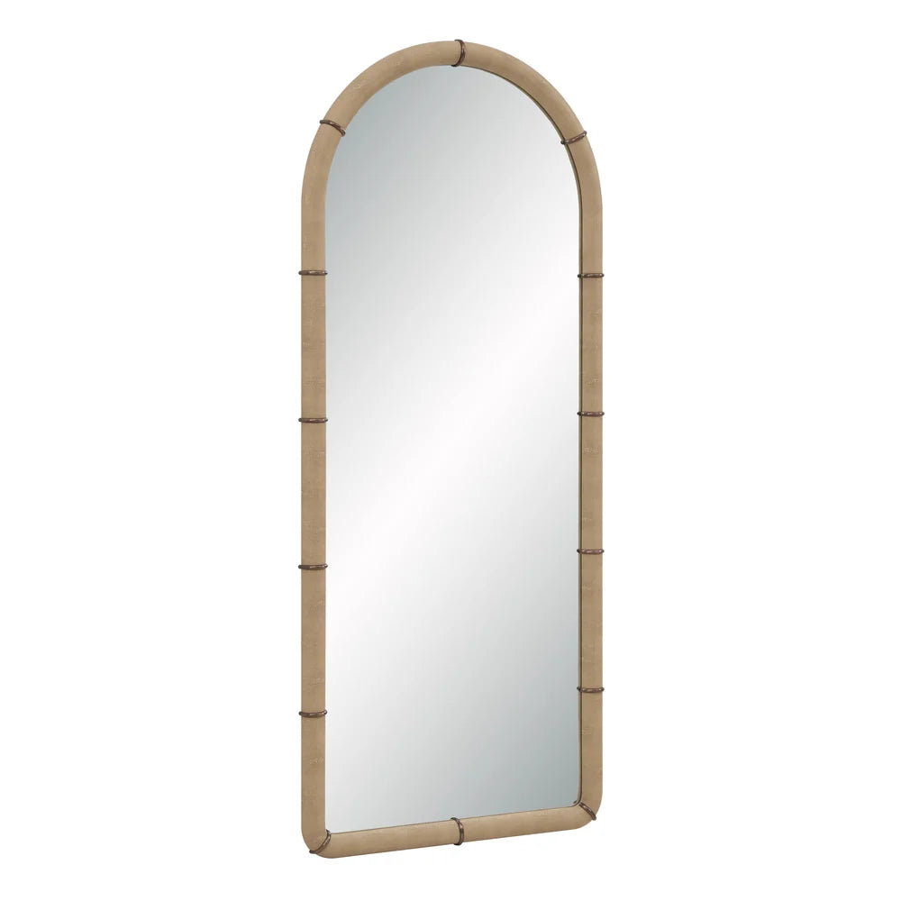 Angled view of the Mirelle Full-Length Mirror showing its tall arched form and beige vegan leather frame with antique metal band accents.