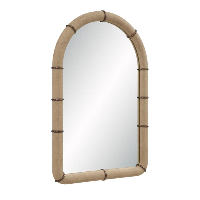 Angled view of the Mirelle Wall Mirror showing its arched form and beige vegan leather frame with antique metal band accents.
