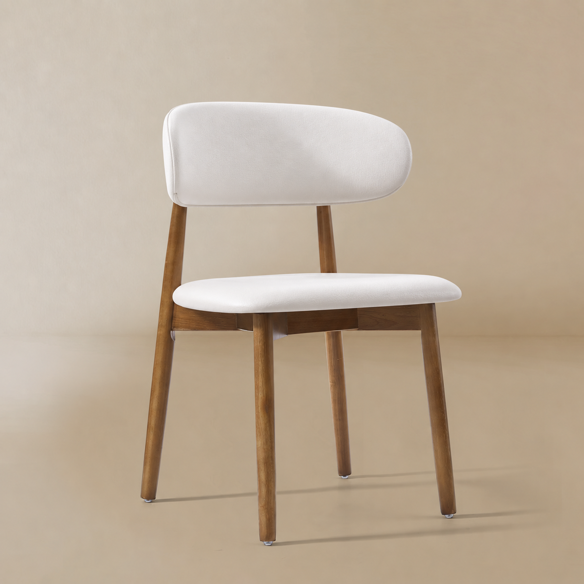 Angled front view of a cream PU leather dining chair with a curved backrest and walnut-finished ash wood frame featuring the Modern PU Leather Ash Wood...