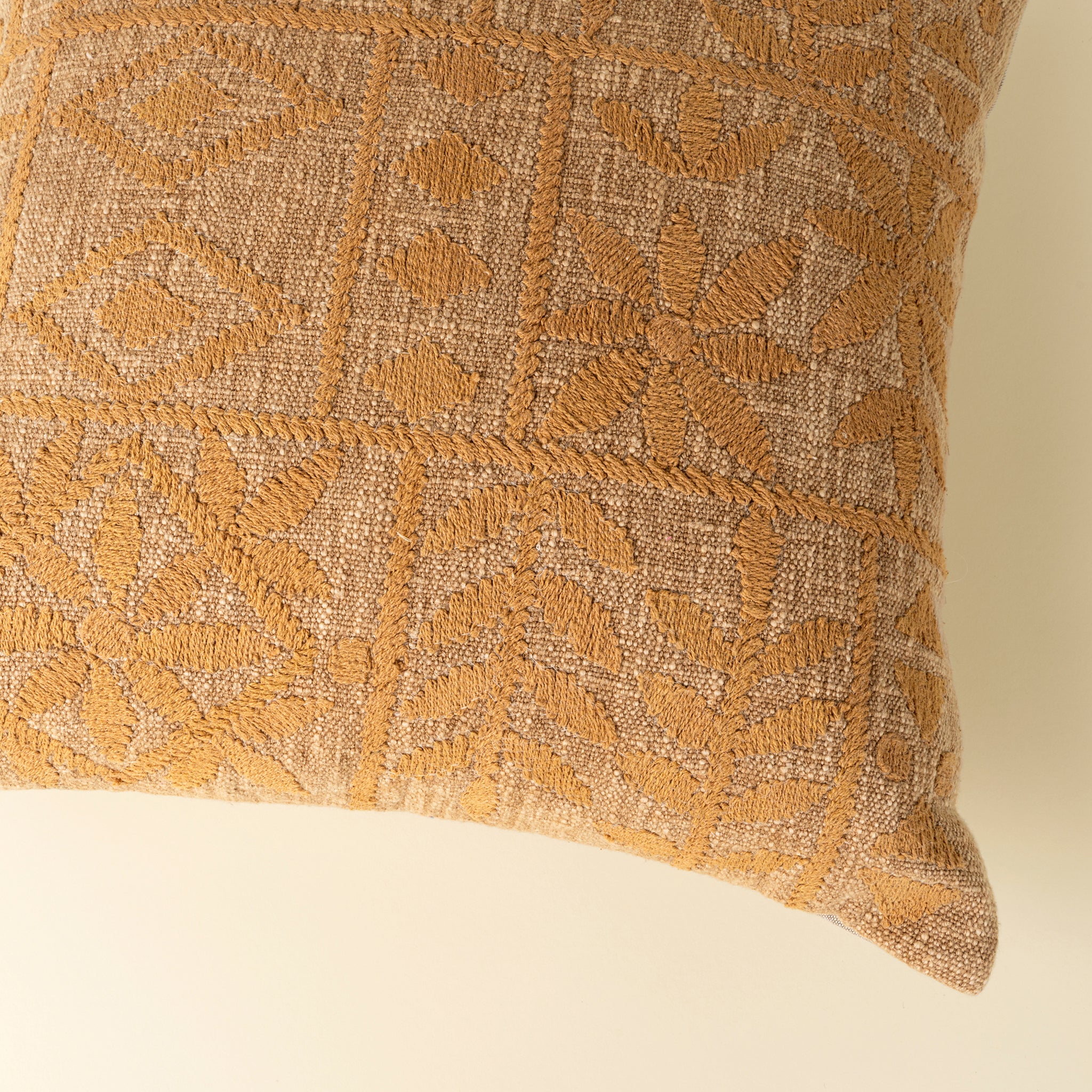 Textured pillow with geometric pattern on a beige background