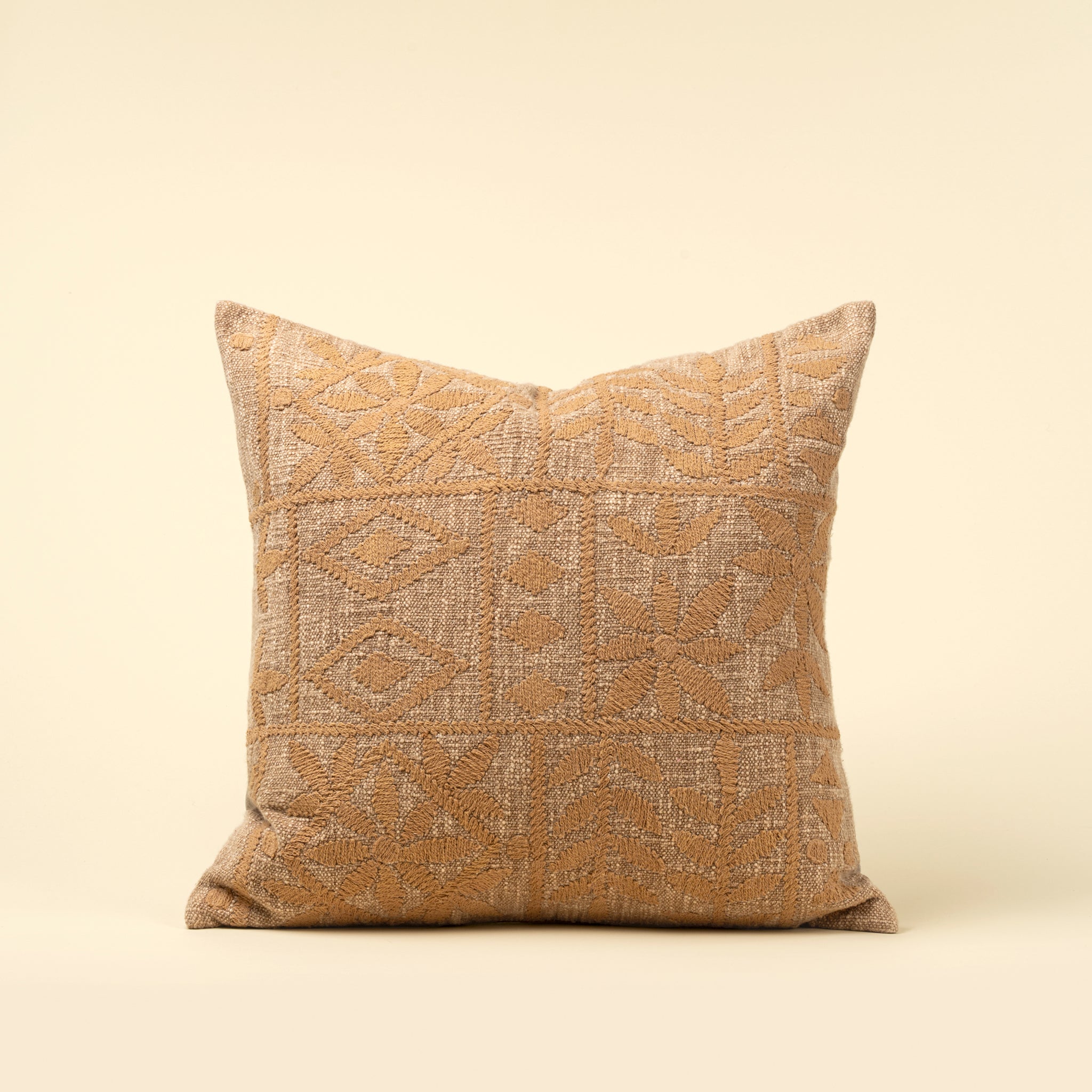 Textured pillow with geometric pattern on a beige background