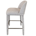 Side profile view of the Myla upholstered counter stool highlighting its thick seat, curved back, and sturdy fabric-wrapped legs.
