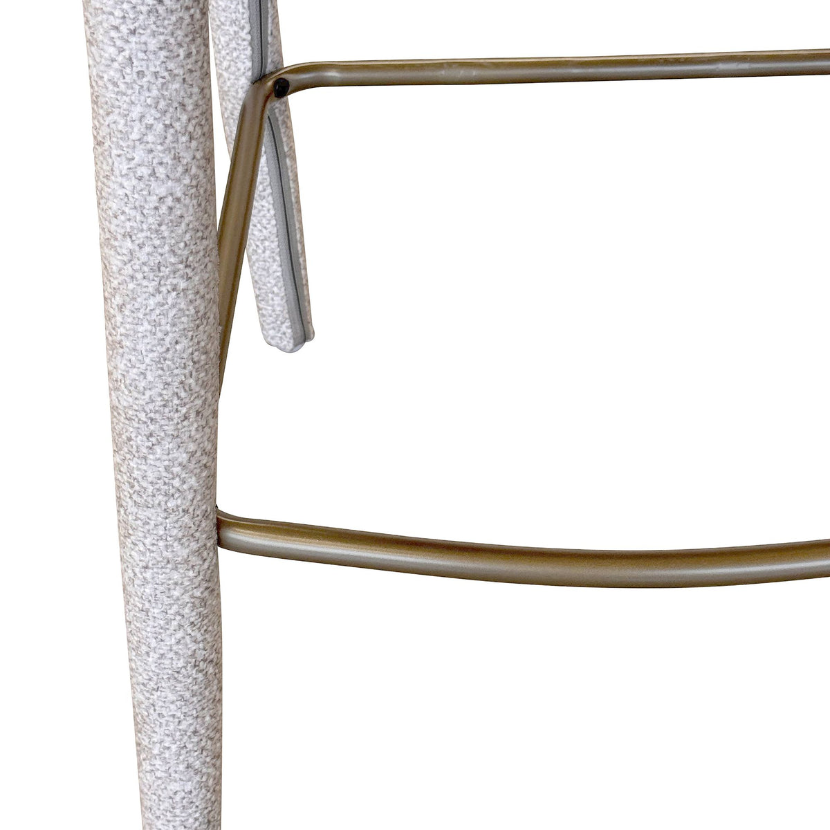 Close-up of the ivory Myla Counter Stool textured fabric and antique brass footrest