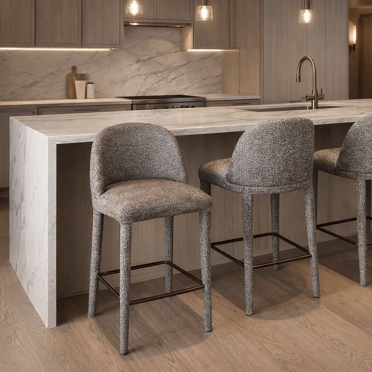 Two grey Myla Counter Stools styled at a modern marble kitchen island