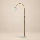 Noemi marble arc floor lamp featuring a plated antique brass frame and opal glass shade on a beige studio background.