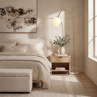 Noemi floor lamp styled beside a neutral bed in a softly lit bedroom.