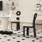Obsidian Loop Dining Chair styled in a modern dining space, featuring a sculpted black looped backrest and soft bouclé seat