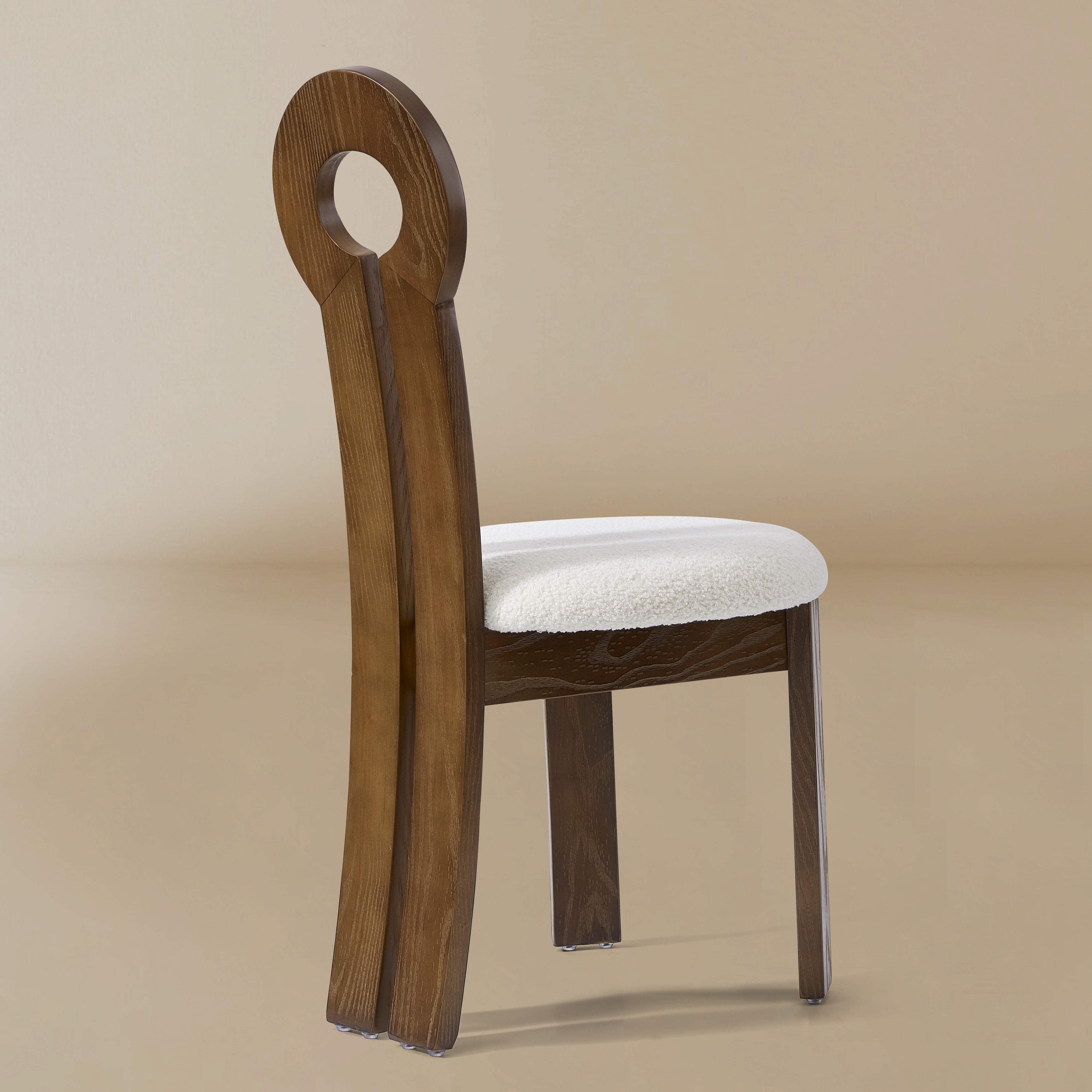 Angle view of the Obsidian Loop Dining Chair in a light beige studio background