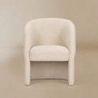 Octavia cream upholstered dining armchair on a warm beige studio background