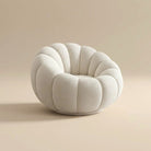Round, cushioned chair with a textured surface on a beige background