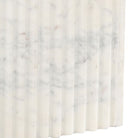 Fluted marble table base detail with veining pattern