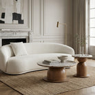 Modern living room with a boucle sofa, marble and wooden coffee table and side table.