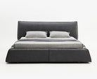 Paris Elegance Grey Platform Bed with plush upholstered headboard and patterned bedding on white studio background