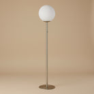 Pearl Glow Floor Lamp with round white globe shade and slim metallic stand on neutral background.