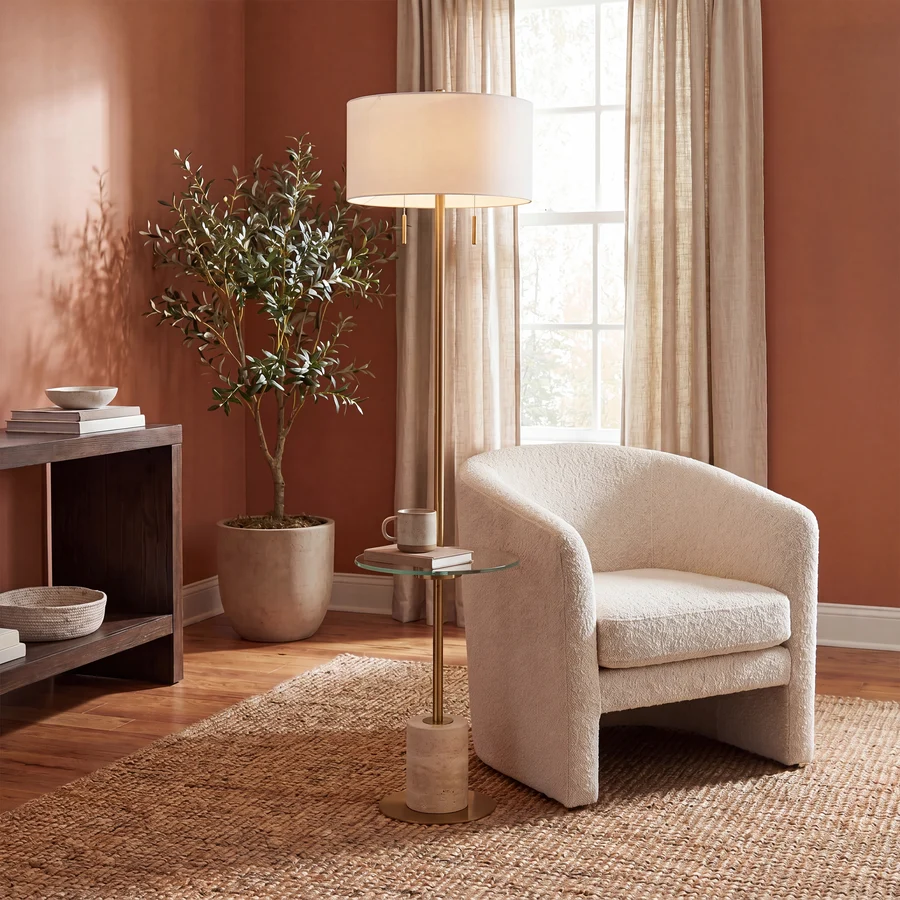 Perrin floor lamp styled beside a white lounge chair in a warm living room.