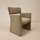 [Plena Dining Chair] Three-quarter front view showing the upholstered panel sides, rounded seat, and open-back design.