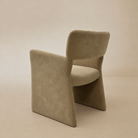 [Plena Dining Chair] Rear three-quarter view showing the chenille-covered backrest and panel sides.