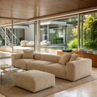 Beige sectional sofa in a modern living room with large windows.