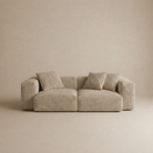 Beige sofa with three cushions on a beige background