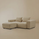 Beige plush corduroy modular sofa with two seater and ottoman configuration in a studio background