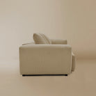 Side view fo the beige plush corduroy modular sofa in a studio background