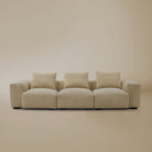 Beige plush corduroy modular sofa in sectional configuration in a studio background
