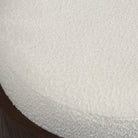 Macro close-up of the soft, nubby white bouclé fabric texture on the top seat of the Rondo round vanity stool.
