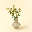 Vase with yellow flowers on a beige background