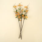 Artificial plant branches with orange berries on a beige background