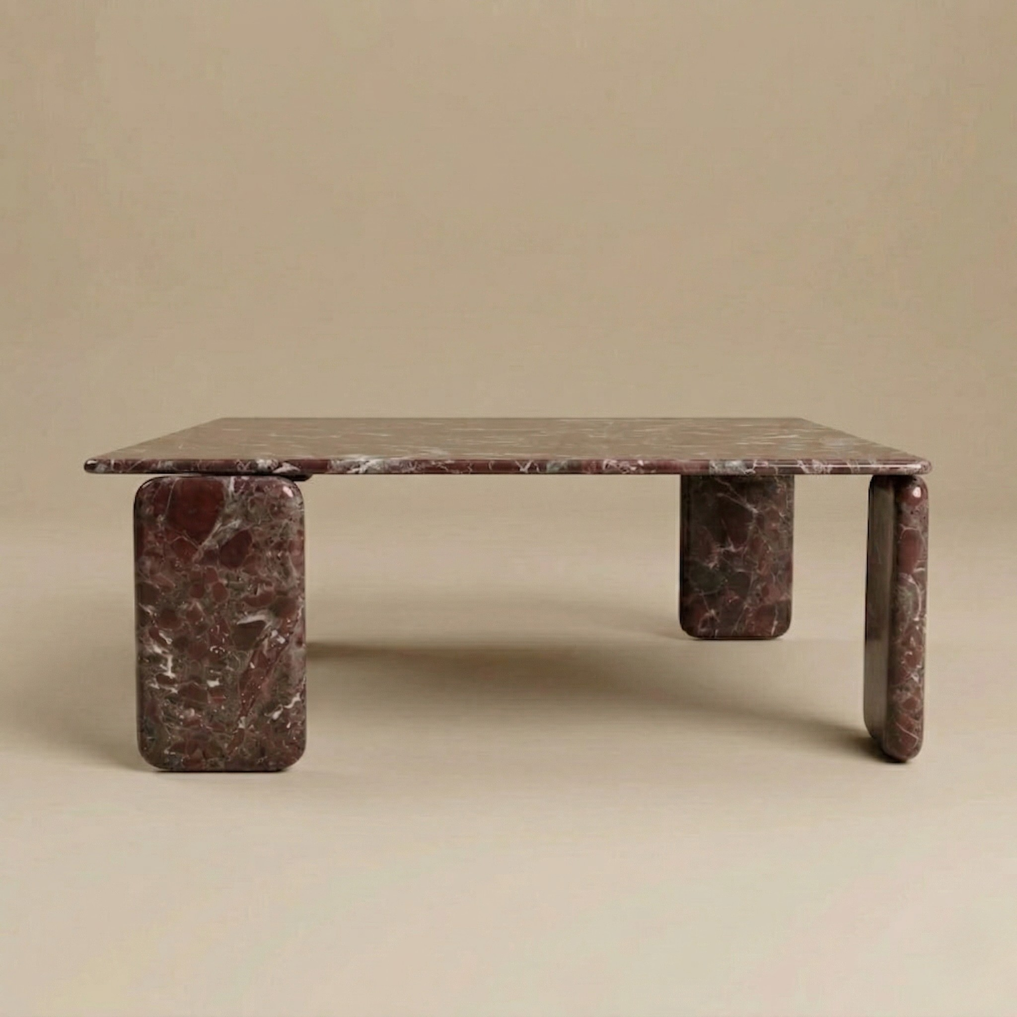 Marble coffee table with a red veined pattern on a beige background