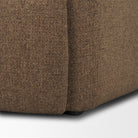 Close up of the bottom corner of the Rowan chair showing the durable mocha upholstery.