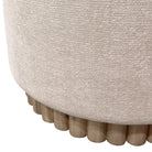 Close-up of a textured beige ottoman with wooden legs on a white background