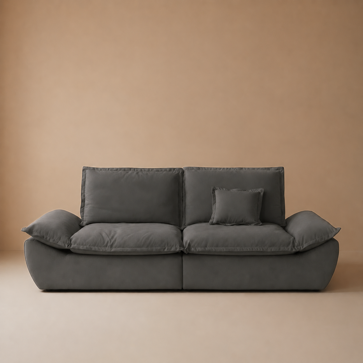 Front studio view of the compact sailing-shaped loveseat in charcoal with a matching decorative toss pillow.