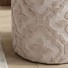 Textured beige ottoman on a wooden floor