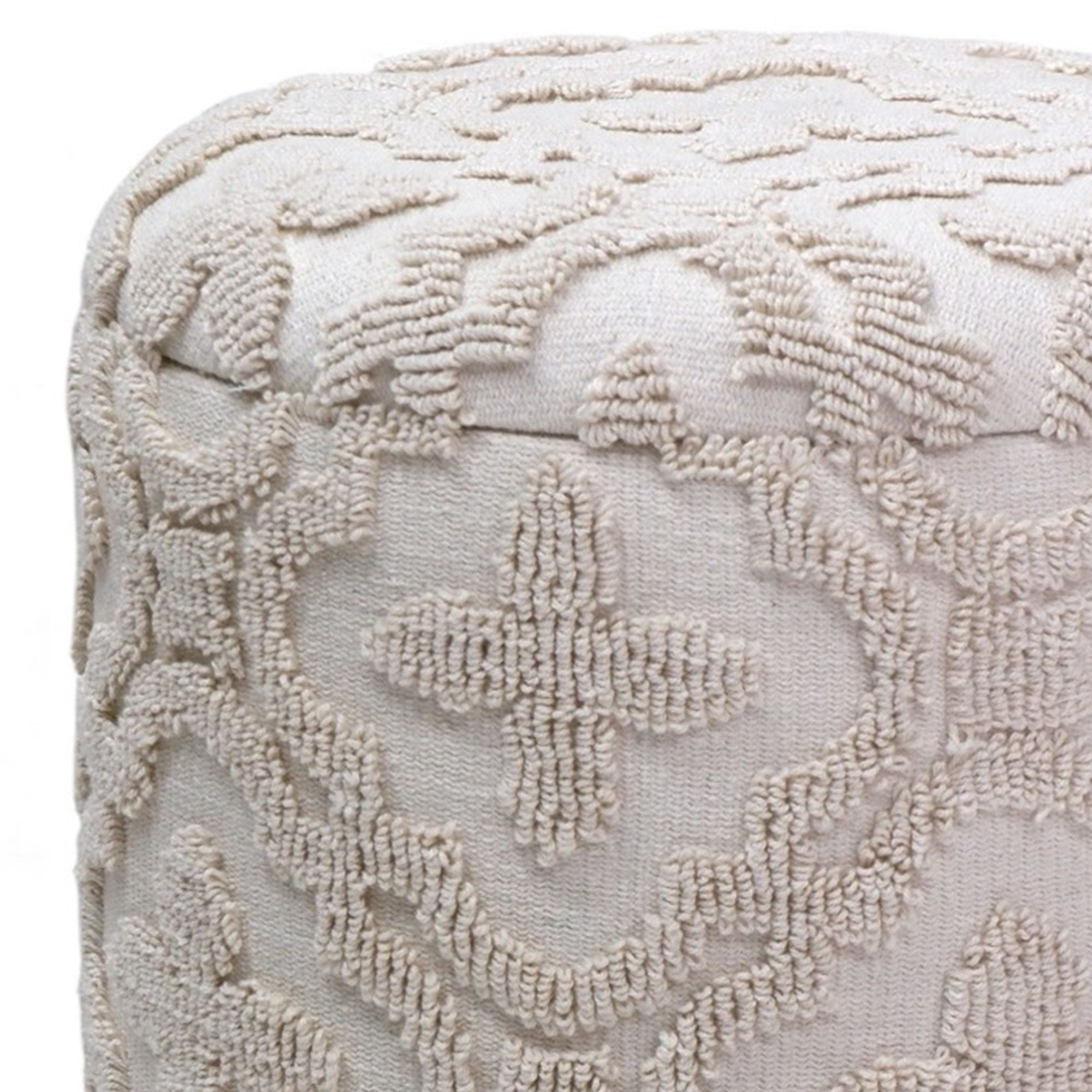 Textured beige ottoman with intricate pattern on a white background
