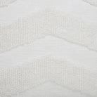 Macro close-up of the raised tufted chevron pattern and flat woven cream base on the Seraphina knitted pillow.