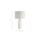 Table lamp with a white shade and textured base on a white background