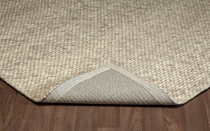 Folded corner of the ivory Silas hand-woven wool rug showing its thick loops and durable woven backing