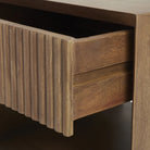Close-up macro shot of the Silva nightstand showcasing the intricate vertical fluting detail and natural mango wood texture