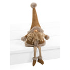 A brown and beige Christmas gnome doll with a long pointed hat, shaggy beard, and dangling legs, sitting on a white wooden step against a white background.