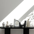 Solene Ceramic Vase styled on black shelf with modern sculptural vases in soft natural light