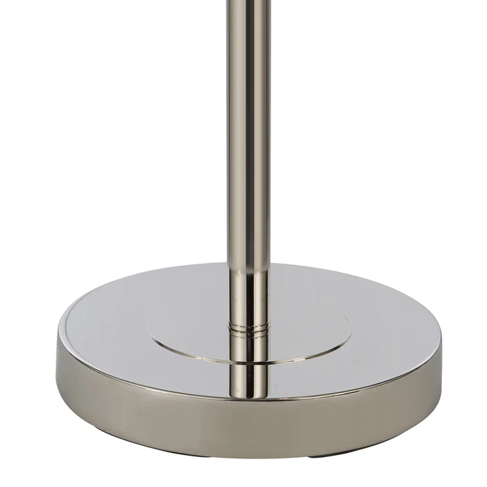 Close-up of the Solenne floor lamp's round polished nickel iron base.