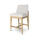 Angled studio view of the Sterling counter stool highlighting the elegant joinery where the wood frame meets the upholstered back.