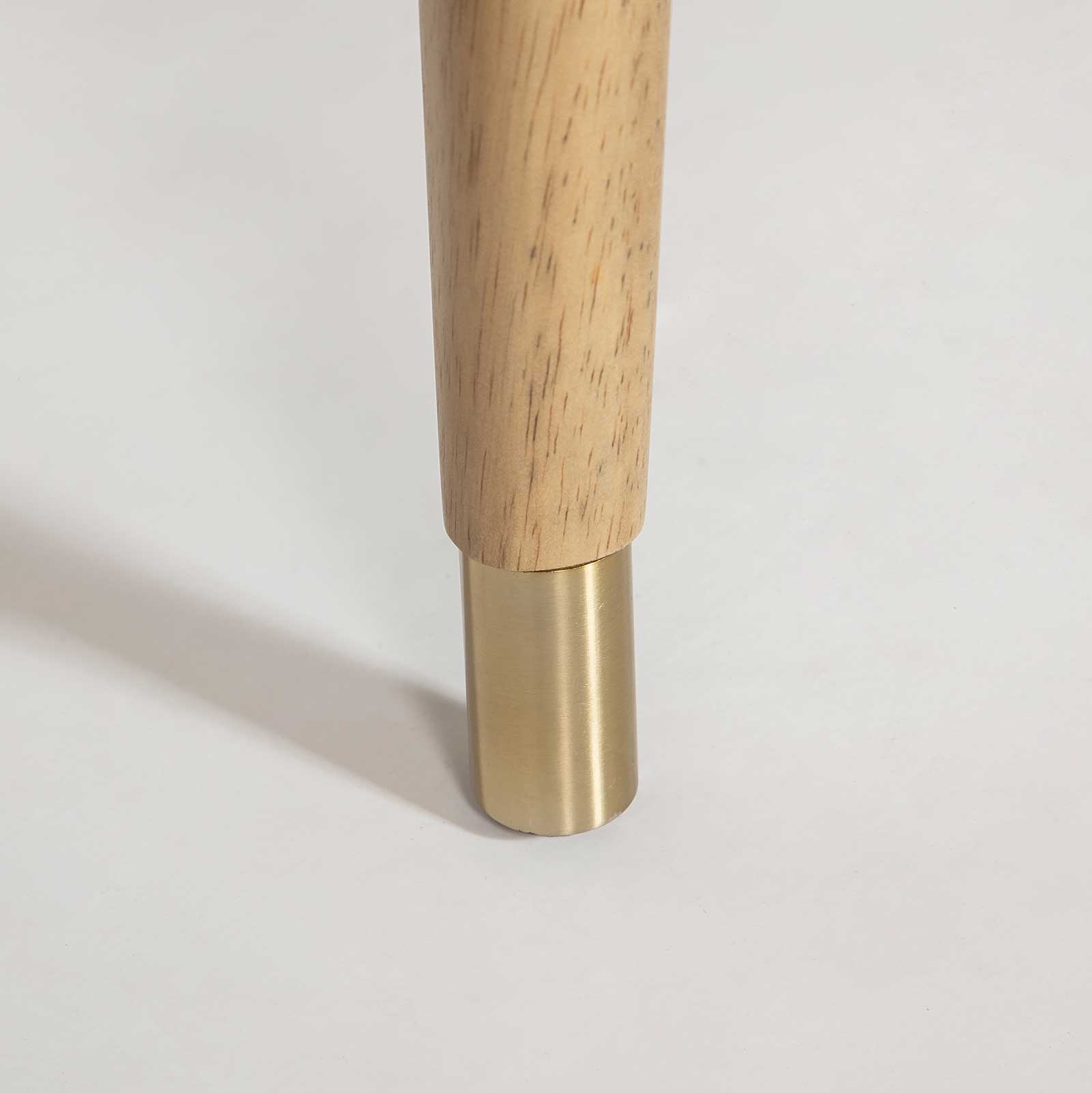 Close-up of the Sterling counter stool base featuring blonde wood legs, brushed brass ferrules, and a matching metal footrest bar.