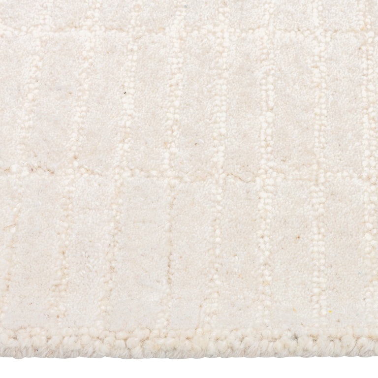 Close-up of the Tessera Hand-Tufted Wool Grid Rug in ivory showing its soft wool pile and subtle raised grid texture.