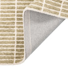 Tessera Hand-Tufted Wool Grid Rug in sage folded back to show its cotton backing and finished edge.