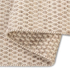 Folded corner of the husk Theo hand-woven rug revealing the consistent honeycomb weave pattern on both sides