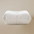 Front view of the White TOGO ottoman on a beige background